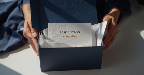 Fashion brand's premium branded shipping box being unboxed — elegant post-purchase resolution experience