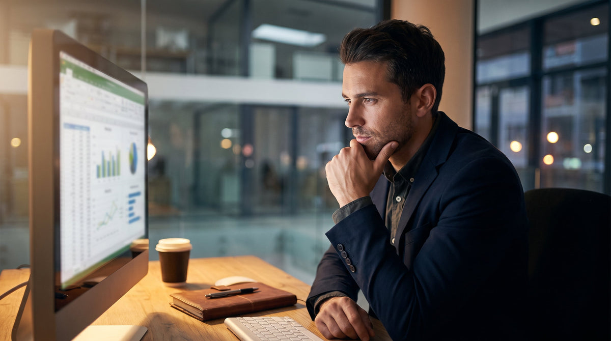 An analyst reviewing transactions on a monitor in a focused office, representing detecting store-credit refund abuse.
