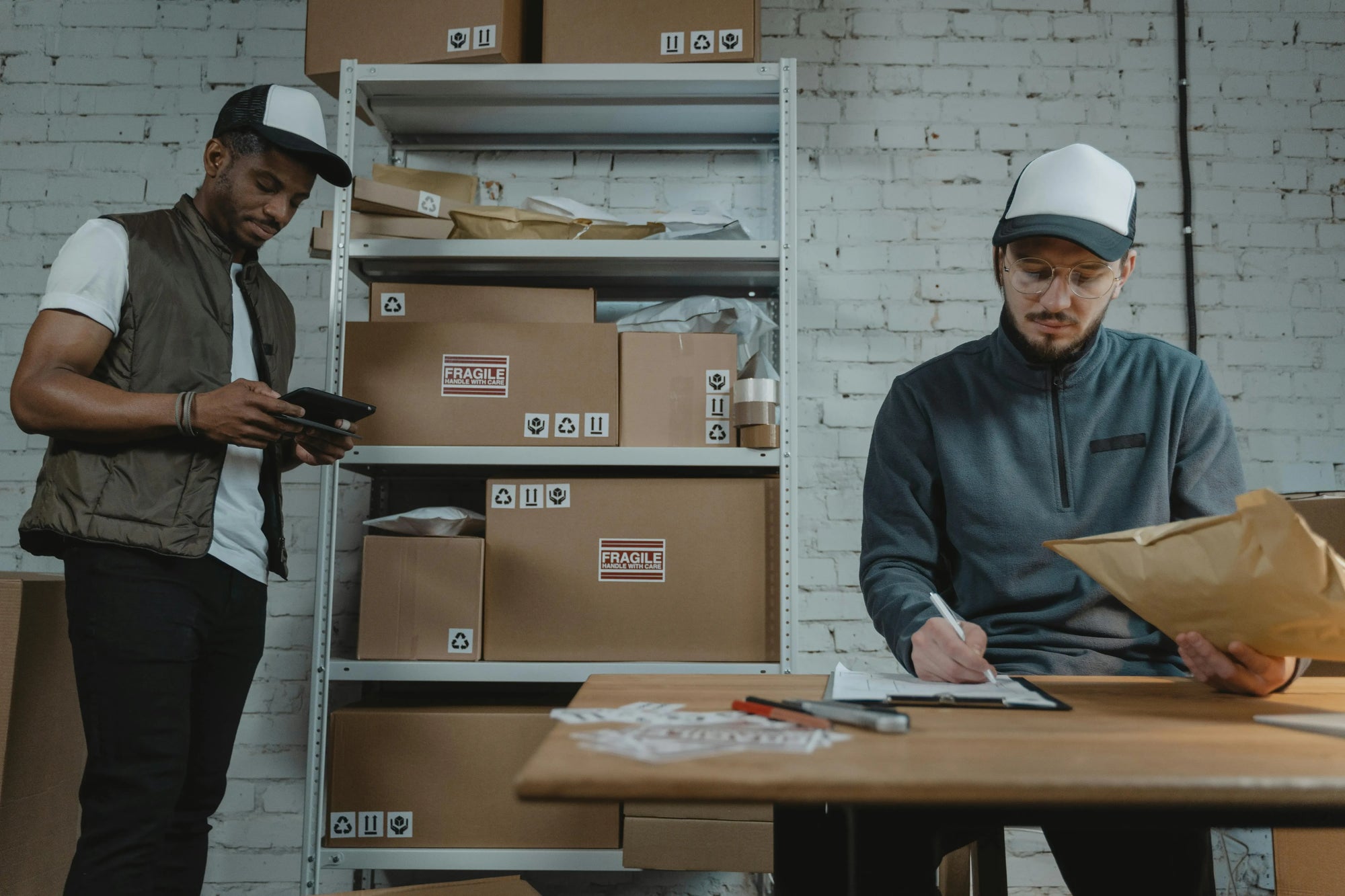 Warehouse worker updating a shipping label on a package after a customer corrected their delivery address through a self-serve order edit link.