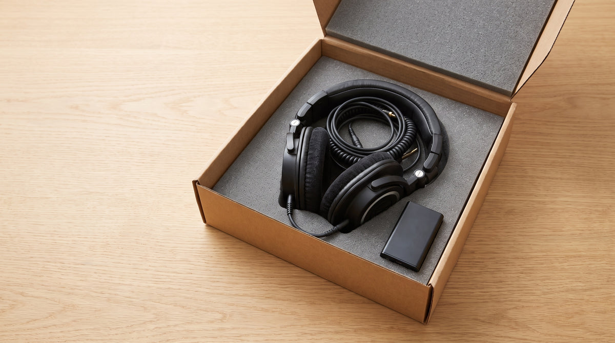 A returned electronic device in an open box on a desk, representing rethinking full refunds on working electronics returns.
